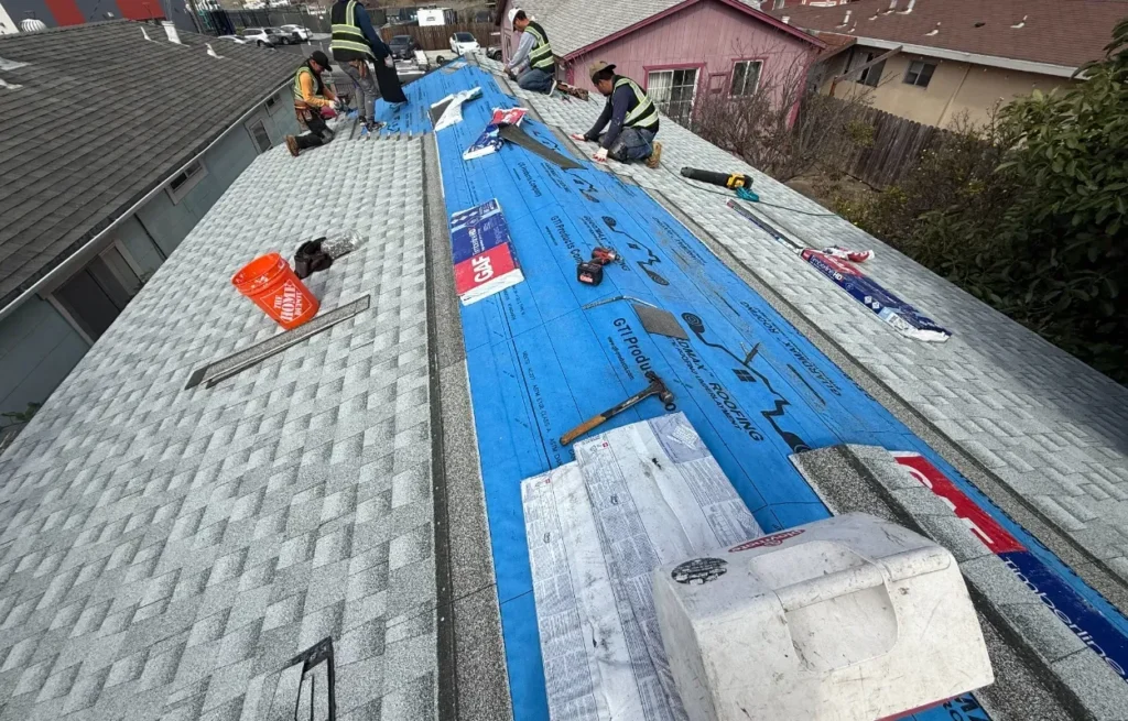 image of a shingle roof under replacement. The image shows blue underlay GAF shingles in the image.