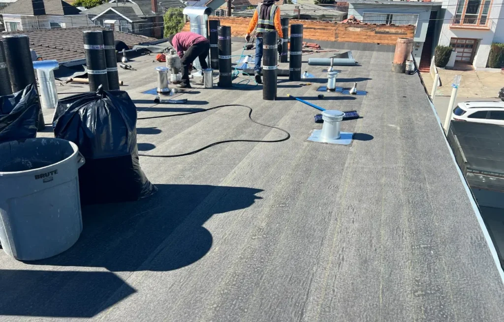 Image of a flat roof with Rubber modified bitumen rolls and other roofing materials on the roof